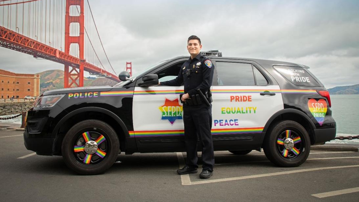 Policial de São Francisco com viatura e uniforme em homenagem a Parada LGBTQ+