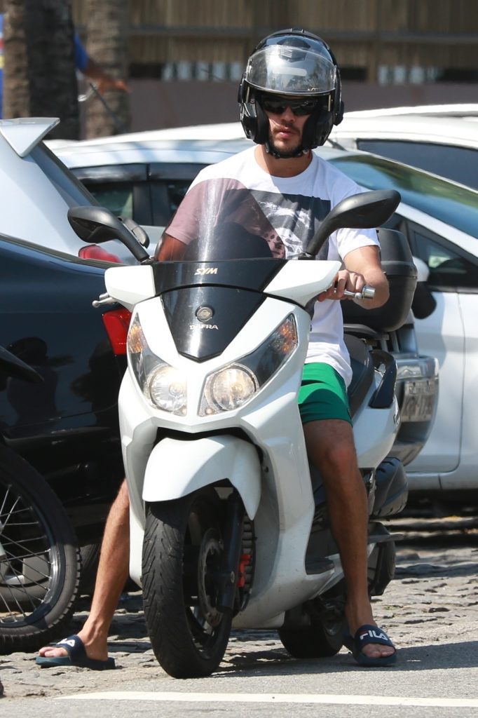 José Loreto dirigindo moto na orla da Barra da Tijuca