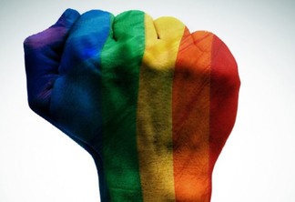Imagem de punho erguido com a bandeira do arco-íris