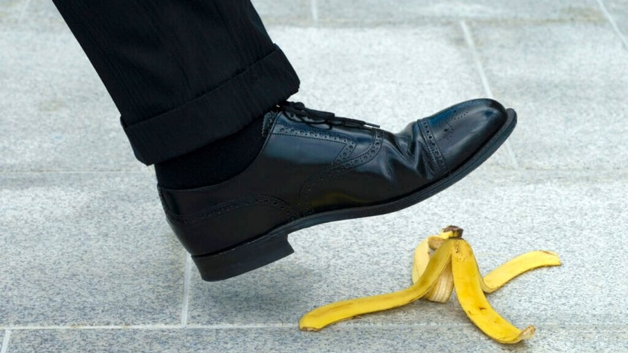 Businessman stepping on banana skin